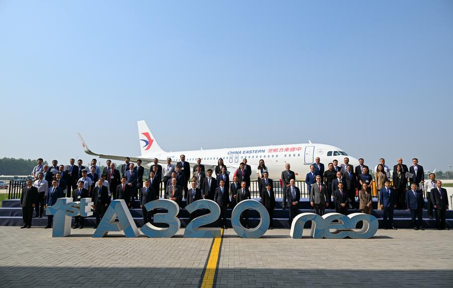 16일 에어버스 톈진(天津) A320 시리즈 항공기 두 번째 최종 조립라인에서 인도된 항공기를 배경으로 기념사진을 찍는 귀빈. (사진/신화통신)