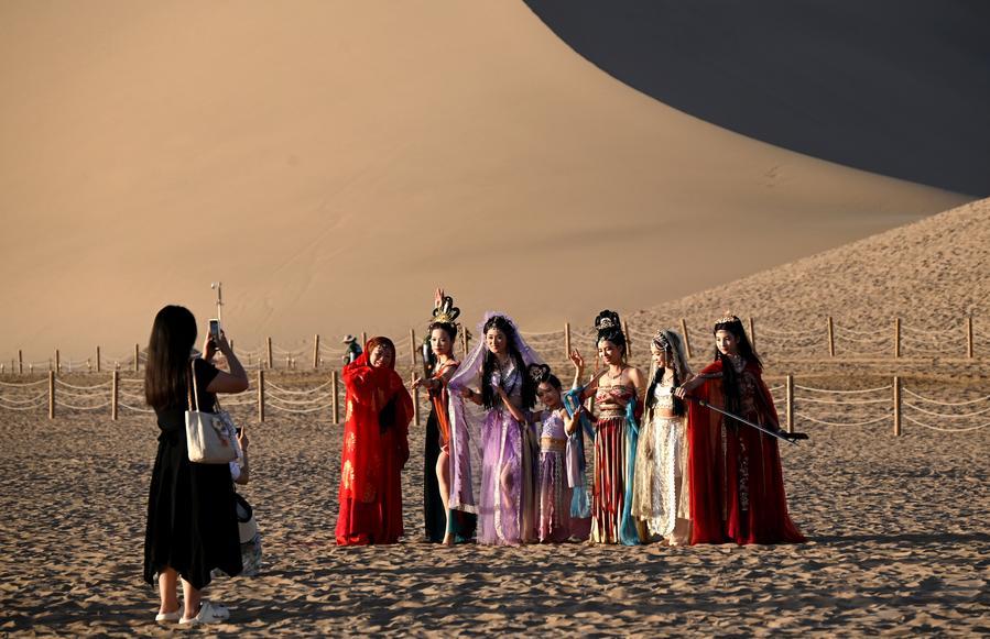 지난 6일 간쑤(甘肅)성 둔황(敦煌)시 밍사산(鳴沙山) 웨야취안(月牙泉) 관광지에서 관광객들이 사진을 찍고 있다. (사진/신화통신)