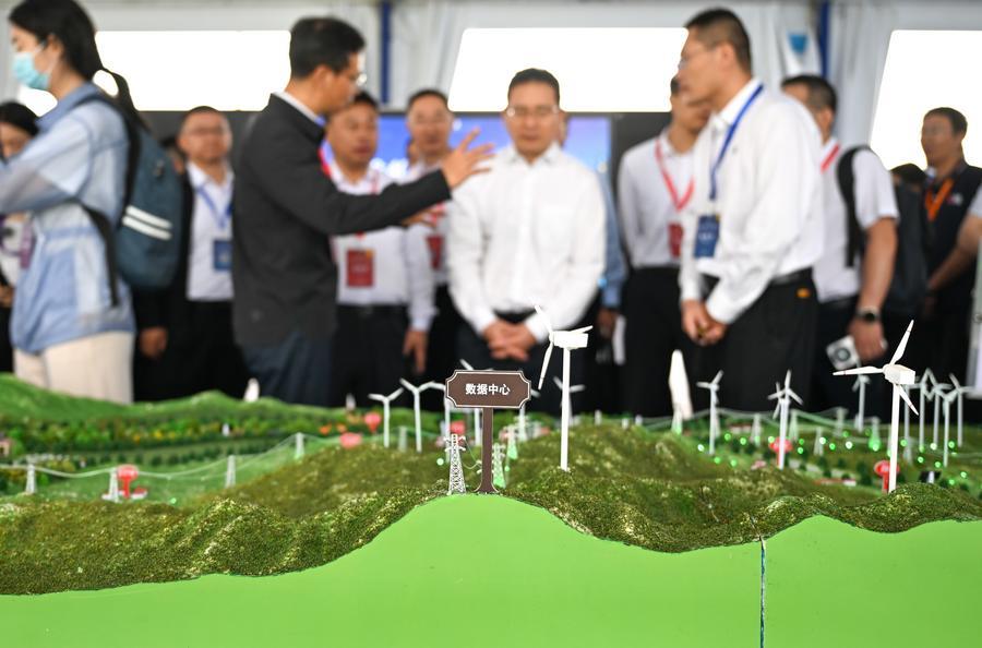 지난 22일 '2026 녹색 컴퓨팅 파워(인공지능) 대회'의 외부 전시구역을 둘러보는 참가자들. (사진/신화통신)