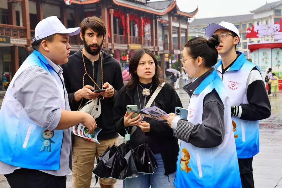 장자제 국가삼림공원 우자위(吳家峪) 매표소 광장에서 외국인 관광객에게 안내해주고 있는 자원봉사자. (사진/신화통신)