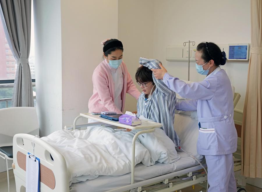 간호사(왼쪽)와 간병인(오른쪽)이 지난 2월 26일 상하이시 폐과의원 외과 병동에서 환자에게 수술 후 재활 훈련을 돕고 있다. (사진/신화통신)