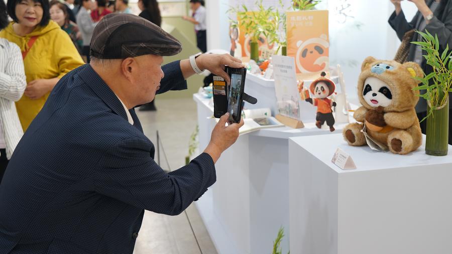 한 한국인 관람객이 지난 16일 서울 강북문화예술회관에서 열린 청두(成都) 문화관광 홍보 행사에서 전시품을 촬영하고 있다. (사진/신화통신)