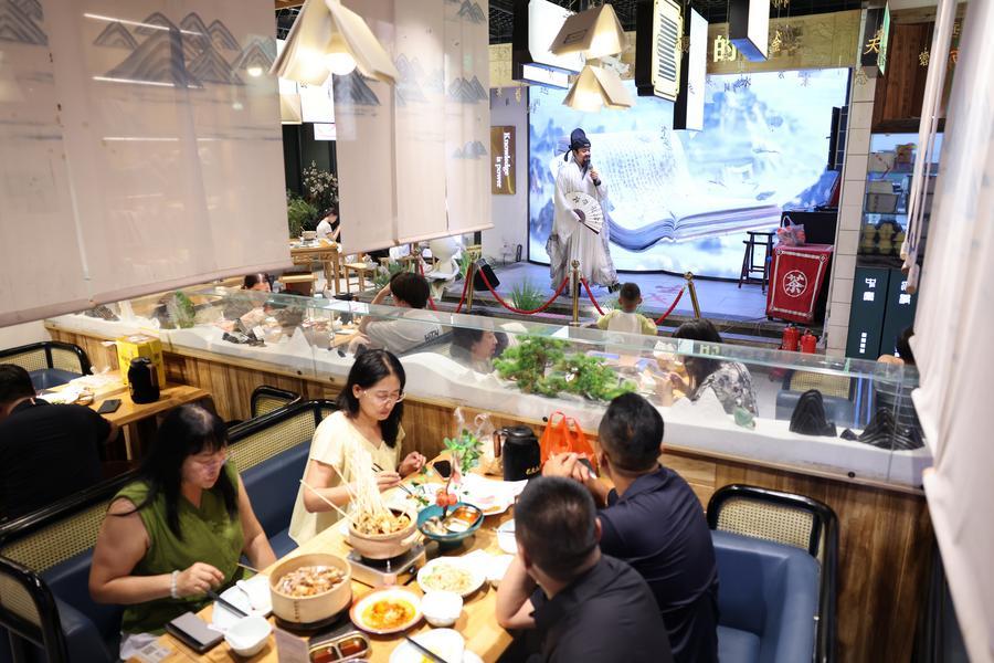 지난 20일 산시(陝西)성 시안(西安)시 중러우(鐘樓)관광지 인근의 '창안다파이당(長安大牌檔)'에서 시선(詩仙) 이백(李白)의 역할을 맡은 배우가 손님과 시를 주고 받고 있다. (사진/신화통신)