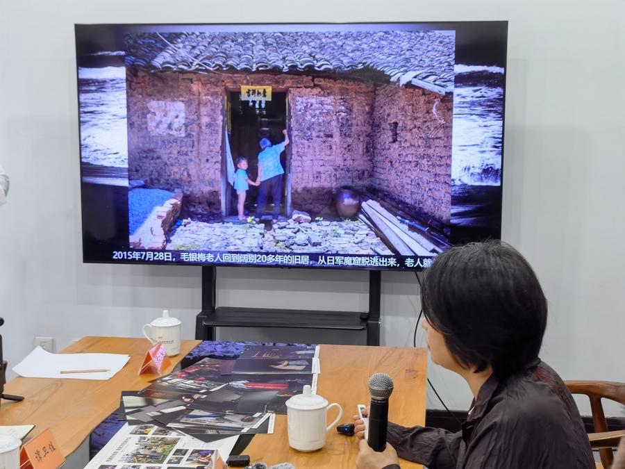 옌메이화(晏美華)가 자신이 촬영한 '위안부' 피해자 마오인메이(毛銀梅, 한국명 박차순)의 사진을 보여주고 있다. (사진/신화통신)