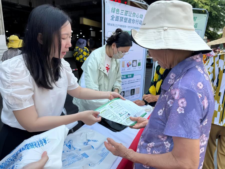 지난해 4월 23일 하이난(海南)성 싼야(三亞)시의 한 농산물 시장에서 직원들이 플라스틱 사용 금지 홍보 활동을 펼치고 있다. (취재원 제공)