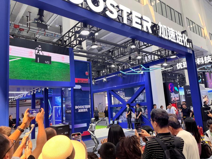 19일 WRC를 찾은 관람객이 자쑤진화(加速進化·Booster Robotics) 로봇 공연을 관람하고 있다. (사진/신화통신)