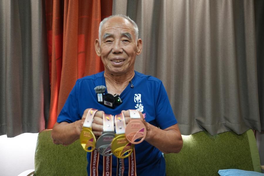 뤼밍푸(呂明璞)가 '2026 대구세계마스터즈육상경기대회(WMAC)'에서 따낸 메달을 보여주고 있다. (사진/신화통신)