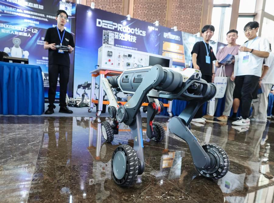 17일 '제9회 중국 로봇 서밋'에 참가한 항저우 윈선추(雲深處)테크회사(DEEP Robotics) 직원이 전 지형 이동 가능 바퀴형 로봇을 선보이고 있다. (사진/신화통신)