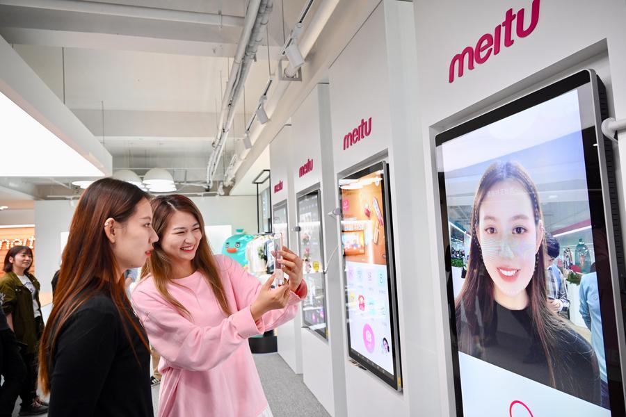 지난 2020년 11월 10일 푸젠(福建)성 샤먼(廈門)시에 위치한 메이투(美圖) 회사 전시홀에서 직원들이 메이투 앱(APP)으로 사진을 찍고 있다. (사진/신화통신)